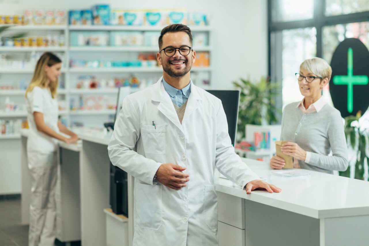 young female pharmacist posing while working in a pharmacy e1697689073593